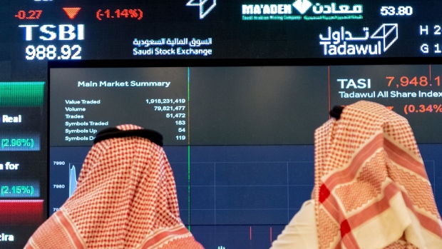 Visitors look at stock price information displayed on a digital screen inside the Saudi Stock Exchange, also known as the Tadawul, in Riyadh, Saudi Arabia, on Tuesday, April 10, 2018. Foreign investors bought more Saudi stocks in March than ever before in anticipation of the kingdoms upgrade to emerging-market status. Photographer: Bloomberg/Bloomberg