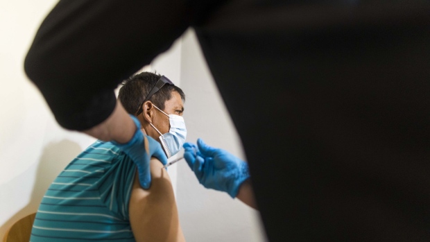 A healthcare worker administers a dose of the Pfizer-BioNTech Covid-19 vaccine at a vaccination site in Lake Worth, Florida, U.S., on Friday, Aug. 13, 2021. Florida's weekly Covid-19 cases rose to a record, with confirmed infections increasing 12% to 151,415 for the seven days through Thursday as Governor Ron DeSantis stakes his claim against mask mandates.