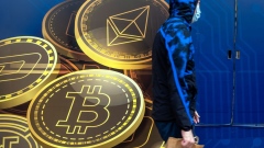 A pedestrian walks past signage for Ethereum, top, and Bitcoin outside the Hong Kong Digital Asset Exchange Ltd. digital currency trading store in Hong Kong, China, on Thursday, June 24, 2021. Hong Kong Digital Asset Exchange is a cryptocurrency platform and is the first to combine online and physical exchange in Hong Kong.