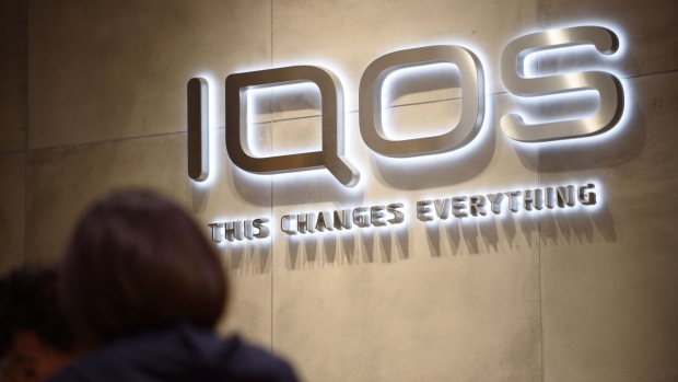 The logo of Philip Morris International Inc.'s IQOS smokeless tobacco devices is displayed at IQOS Store Ginza in Tokyo, Japan, on Monday, June 26, 2017. By next week, smokeless devices by Japan Tobacco Inc., British American Tobacco Plc and Philip Morris International will be sold in Tokyo, vying to dominate the race for next-generation tobacco products. Photographer: Akio Kon/Bloomberg