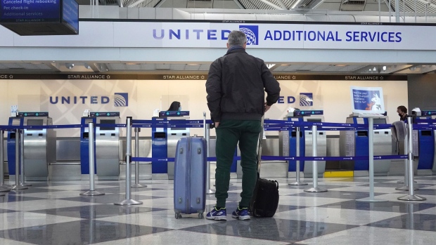 CHICAGO, ILLINOIS - FEBRUARY 05: A passenger arrives for a United Airlines flight at O'Hare International Airport on February 05, 2021 in Chicago, Illinois. United Airlines and American Airlines, two of the nation’s largest carriers, are anticipating having to furlough thousands of employees as both companies continue to see a pandemic-related lag in air travel. (Photo by Scott Olson/Getty Images) Photographer: Scott Olson/Getty Images North America