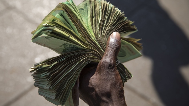 HARARE, ZIMBABWE - AUGUST 05: A man holds Zimbabwean Dollar Bond Notes on August 05, 2018 in Harare, Zimbabwe. Zimbabwe Electoral Commission (ZEC) officials have announced the re-election of President Emmerson Mnangagwa of the ruling Zimbabwe African National Union - Patriotic Front (ZANU-PF). The election was the first since Robert Mugabe was ousted in a military coup last year, and featured a close race between Mnangagwa and opposition candidate Nelson Chamisa of the Movement for Democratic Change (MDC Alliance). Deadly clashes broke out earlier in the week following the release of parliamentary election results, amid allegations of fraud by Chamisa and MDC supporters. (Photo by Dan Kitwood/Getty Images)