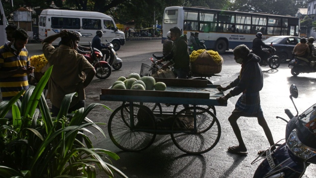 A man pushes a cart with melons at a wholesale vegetable market in Bengaluru, India, on Wednesday, Oct. 13, 2021. The rupee has come under pressure as surging commodity prices rekindled worries about inflation and the financial health of the net oil-importing nation.