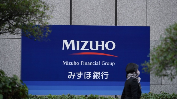 A pedestrian walks past a branch of Mizuho Bank Ltd. in Tokyo, Japan, on Monday, Nov. 9, 2020. Japanese banks expect business opportunities from digitalization, thanks to Prime Minister's Yoshihide Suga's pledge to overhaul outdated paper-based processes. Photographer: Akio Kon/Bloomberg