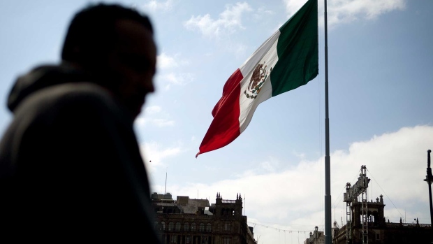 The Mexican flag flies in the Zocalo main square in Mexico City, Mexico, on Friday, Nov. 6, 2009. Mexico's economy will grow 3.1 percent in 2010, after falling an estimated 6.8 percent this year due to less demand for Mexican manufactured products amid the recession. Photographer: Bloomberg/Bloomberg