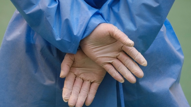 A health worker wears latex gloves at a Covid-19 testing centre set-up in the grounds of the Richland Gardens housing estate in the Kowloon Bay area of Hong Kong, China, on Thursday, Dec. 10, 2020. Some residents from one of the developments's tower blocks are being quarantined amid a coronavirus outbreak in the housing estate. Photographer: Roy Liu/Bloomberg