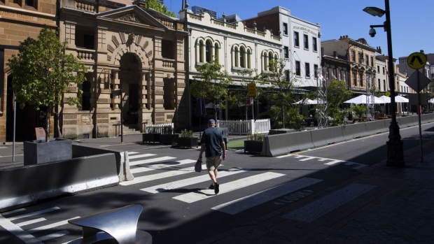 A pedestrian crosses a street in The Rocks area of Sydney, Australia, on Tuesday, Oct. 13, 2020. Australia last week released a fiscal blueprint that pushes debt and deficit to a peacetime record just hours after the central bank signaled a willingness to ease further as both arms of policy press to drive down unemployment.