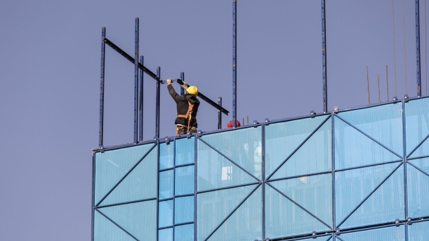A worker installs safety netting at an apartment block under construction in the Nanchuan area of Xining, Qinghai province, China, on Tuesday, Sept. 28, 2021. China has urged financial institutions to help local governments stabilize the rapidly cooling housing market and protect the rights of some homebuyers, another signal that authorities are worried about fallout from the debt crisis at China Evergrande Group. Photographer: Qilai Shen/Bloomberg