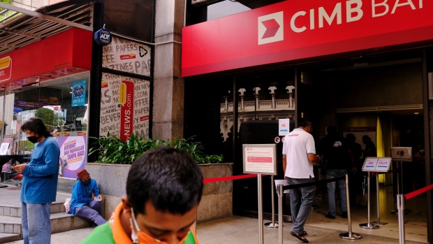 Customers wait in line to enter a CIMB bank branch in Kuala Lumpur, Malaysia, on Wednesday, Aug. 11, 2021. Malaysia has eased virus restrictions for those who have completed the full vaccination regime, allowing them to cross state borders and dine at restaurants as authorities seek to re-open the economy. Photographer: Samsul Said/Bloomberg