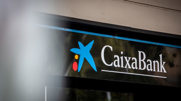 Signage above the entrance to a Caixabank SA bank branch in Barcelona. Photographer: Angel Garcia/Bloomberg