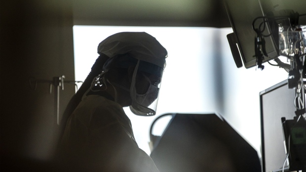 A nurse wearing a powered air-purifying respirator (PAPR) treats a patient inside the Covid-19 intensive care unit (ICU) at PeaceHealth Southwest Medical Center in Vancouver, Washington, U.S., on Thursday, April 30, 2020. The coronavirus outbreak may last for two years and won’t be controlled until about two-thirds of the world’s population is immune, a group of experts said in a report. Photographer: Nathan Howard/Bloomberg