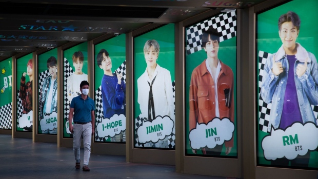 A pedestrian wearing a protective mask walks past an advertisement for K-pop boy band BTS displayed in Seoul, South Korea, on Friday, Sept. 18. 2020. Big Hit Entertainment Co., the manager of K-pop boy band BTS, is looking to raise as much as 962.6 billion won ($812 million) in a South Korean initial public offering that is set to be the country’s largest in three years.