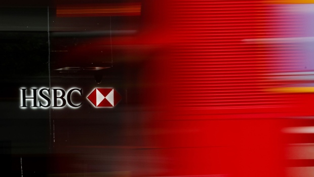 A bus passes a logo of a HSBC Holdings Plc bank branch in London, U.K., on Tuesday, May 2, 2017. HSBC has appeased investors with $3.5 billion of share buybacks, but after five years of declining revenue analysts are looking for evidence the bank is stabilizing its top line when it reports earnings Thursday. Photographer: Luke MacGregor/Bloomberg