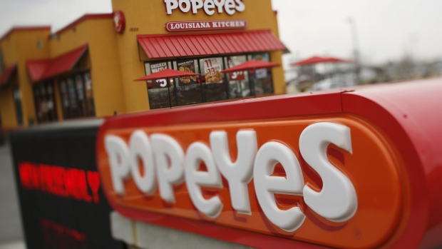 (EDITORS NOTE: Image was created using a variable planed lens.) Signage is displayed outside a Popeyes Louisiana Kitchen Inc. fast food restaurant in Jeffersonville, Indiana, U.S., on Tuesday, Feb. 21, 2017. Restaurant Brands International Inc. agreed to buy Popeyes Louisiana Kitchen Inc. for about $1.8 billion, adding a fried-chicken chain to its lineup of burgers and doughnuts. Photographer: Luke Sharrett/Bloomberg