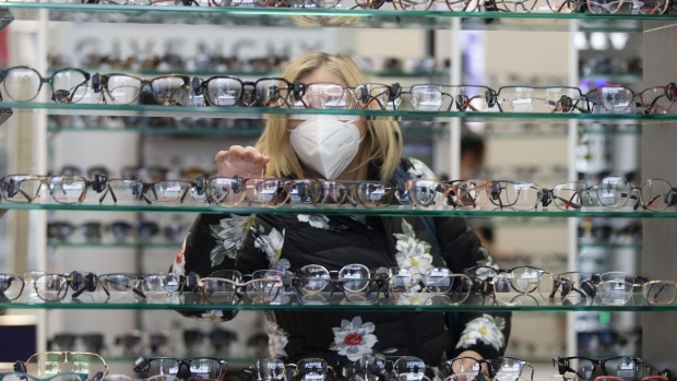 A shopper wearing a protective mask browses glasses in a store in Quebec City.