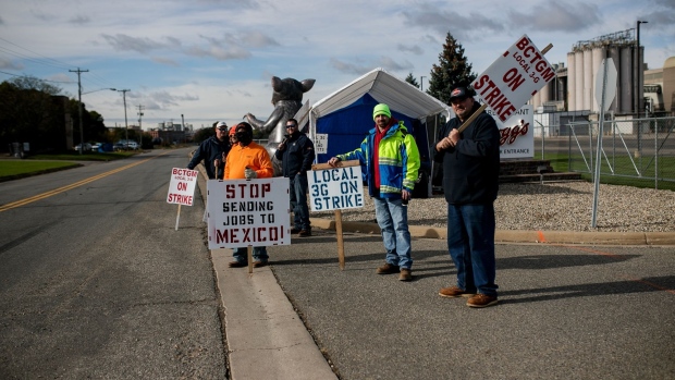 Demonstrators hold signs during a union workers strike outside the Kellogg plant in Battle Creek, Michigan, U.S., on Friday, Oct. 22, 2021. Members of the Building and Construction Trades Council union will return to work Tuesday at the Kellogg Co. cereal factory in Omaha, Nebraska, while the broader strike against the company continues.