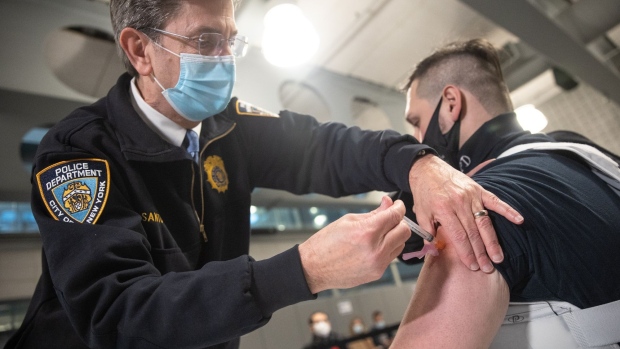 A member of the New York Police Department (NYPD) receives a dose of the Moderna Covid-19 vaccination at Queens Police Academy in the Queens borough of New York, U.S., on Monday, Jan. 11, 2021. New York City Mayor Bill de Blasio reaffirmed his goal of doling out 1 million Covid-19 doses by the end of January.