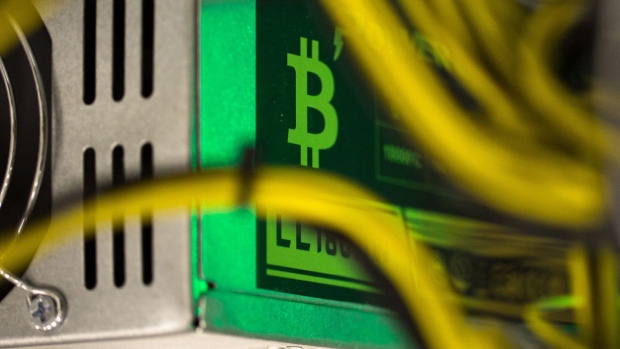 A bitcoin logo sits on a LL 1800W power unit supplying cryptocurrency mining machines at the SberBit mining \'hotel\' in Moscow, Russia, on Saturday, Dec. 9, 2017. Futures on the world’s most popular cryptocurrency surged as much as 26 percent in their debut session on Cboe Global Markets Inc.\'s exchange, triggering two temporary trading halts designed to calm the market. Photographer: Andrey Rudakov/Bloomberg