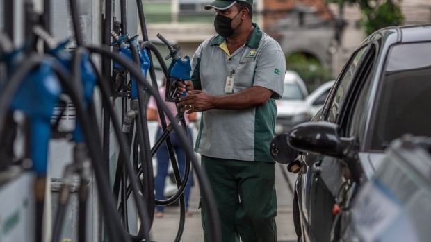 A worker wearing a protective mask fuels a vehicle at a Petroleo Brasileiro SA (Petrobras) gas station in Rio de Janeiro, Brazil, on Friday, Feb. 19, 2021. Petrobras declined after President Jair Bolsonaro said that the company's fuel price increases have been excessive, undermining the company's efforts to dispel concerns about political interference.