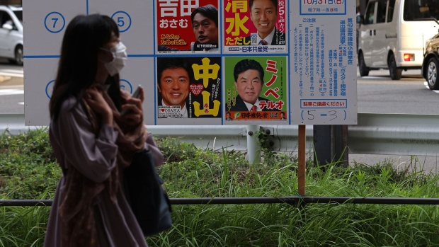 OSAKA, JAPAN - OCTOBER 19: A woman wearing a protective face mask walks past candidate posters, at a temporary election notice board for the upcoming lower house election on October 19, 2021 in Osaka, Japan. Campaigning has begun ahead of the October 31st general election that was called following Fumio Kishida’s win in the Liberal Democratic Party leadership election last month. (Photo by Buddhika Weerasinghe/Getty Images)