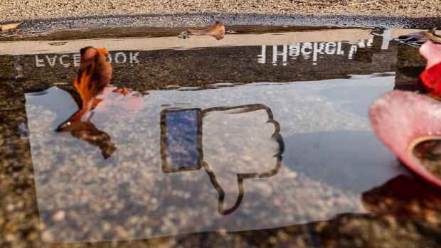 The Facebook logo reflected in a puddle at the company's headquarters in Menlo Park, California, U.S., on Monday, Oct. 25, 2021. Facebook Inc., facing intense scrutiny over its business practices, is planning to rebrand the company with a new name that focuses on the metaverse, according to The Verge. Photographer: David Paul Morris/Bloomberg