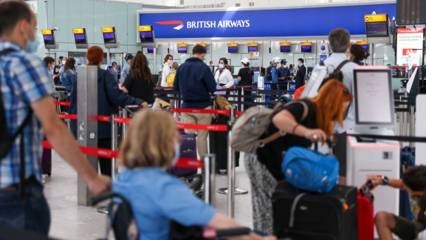 Passengers line up at the British Airways check-in area in Terminal 5 at London Heathrow Airport Ltd. in London, U.K., on Tuesday, July 27, 2021. International Consolidated Airlines Group SA, parent company of British Airways, are due to report earnings on July 30.