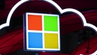 Microsoft Corp. logo, center, hang beside an illuminated iCloud icon at the CeBIT 2017 tech fair in Hannover, Germany.