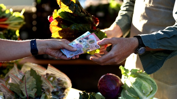 A customer purchases fresh produce at the stall of Moonacres, which comprises of an organic farm, cafe, pop-up restaurant and cooking school, at the Northside Produce Market in Sydney, Australia, on Saturday, Jan. 16, 2021. Australia's economy topped the latest Citigroup Inc. Economic Surprise Indices as authorities' relative success in containing Covid drove a surge in consumer confidence and a rebound in activity. Photographer: Brendon Thorne/Bloomberg