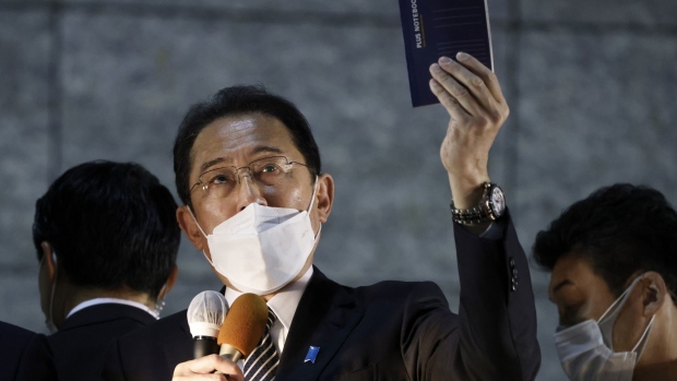 Fumio Kishida, Japan's prime minister, holds up a notebook he uses to write down ideas while speaking during an election campaign event in Tachikawa, Tokyo Metropolis, Japan, on Tuesday, Oct. 26, 2021. Kishida's ruling Liberal Democratic Party (LDP) is likely to keep substantially more than half the seats in parliament in this weekends general election, according to a media poll.