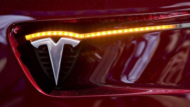 A Tesla Motors logo appears on the side of a Tesla Model S electric sedan as it sits on display outside the Nasdaq Marketsite in New York, U.S., on Tuesday, June 29, 2010. Tesla Motors Inc., the electric car company that hasn't posted a profit, raised $226 million selling shares above its forecast price range in the first initial public offering of a U.S. automaker in a half century. Photographer: Bloomberg/Bloomberg