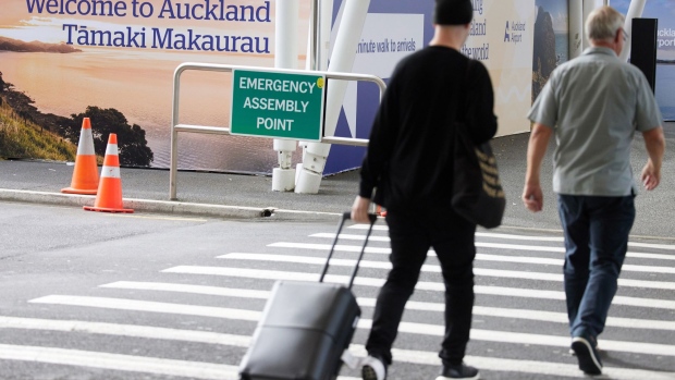 A traveler crosses a road at Auckland International Airport in Auckland, New Zealand, on Monday, April 19, 2021. Australia and New Zealand on Monday started their first quarantine-free flights since the pandemic began, after they successfully halted Covid-19 transmissions from spreading through their nations. Photographer: Brendon O'Hagan/Bloomberg
