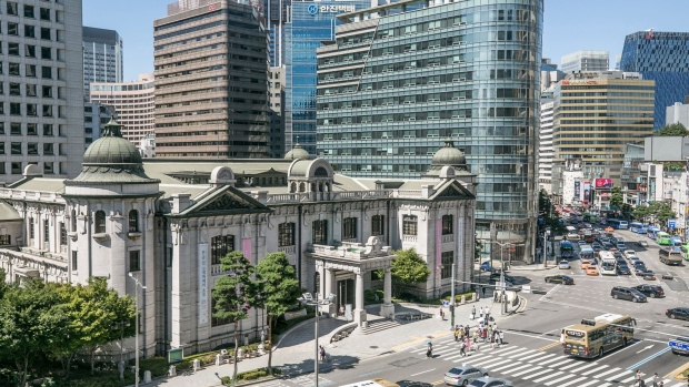 Pedestrians cross a road outside the entrance to the Bank of Korea (BOK) museum at the central bank's headquarters in Seoul, South Korea, on Thursday, Aug. 16, 2018. While the Bank of Korea has indicated that the next move in interest rates is likely to be upward and economists forecast one hike this year, the job market is making that an increasingly tough call. Photographer: Jean Chung/Bloomberg