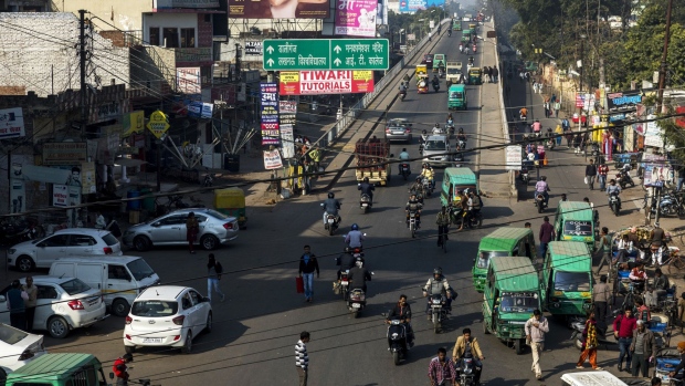 Vehicles and pedestrians pass through an intersection in Lucknow, Uttar Pradesh, India, on Tuesday, February 14, 2017. The success of the Samajwadi government's infrastructure projects has allowed them to hijack Indian Prime Minister Narendra Modi's mantra of development. Now it's possible the Bharatiya Janata Party (BJP) could lose India's most important state election, that began on Feb. 11., endangering further economic reforms and sapping Modi's momentum ahead of the 2019 national elections. Photographer: Prashanth Vishwanathan/Bloomberg