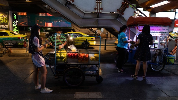A vendor sells fruit to a customer at Siam Square in Bangkok, Thailand, on Thursday, April 29, 2021. Thailand is reworking its vaccine strategy as a month-long soft lockdown to contain its worst wave of Covid-19 infections deepens an economic crisis and risks plans for reopening the crucial tourism industry. Photographer: Luke Duggleby/Bloomberg