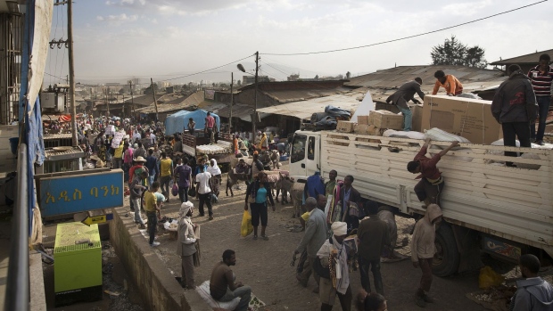 Workers unload boxes of goods at market in Addis Ababa, Ethiopia. Photographer: Simon Dawson/Bloomberg