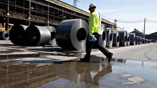 A worker walks past steel coils at the U.S. Steel Corp. Granite City Works facility in Granite City, Illinois, U.S., on Thursday, July 26, 2018. U.S. President Donald Trump celebrated U.S. Steel Corp's decision to re-employ hundreds of laid-off workers and lamented decades of past leaders' trade policies. Photographer: Daniel Acker/Bloomberg
