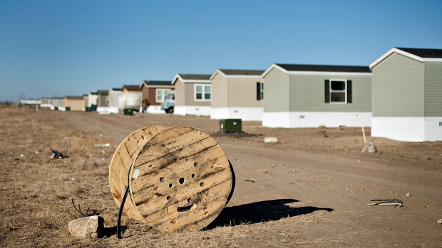 A spool of electrical cable sits near a row of new single wide mobile homes in Williston, North Dakota.