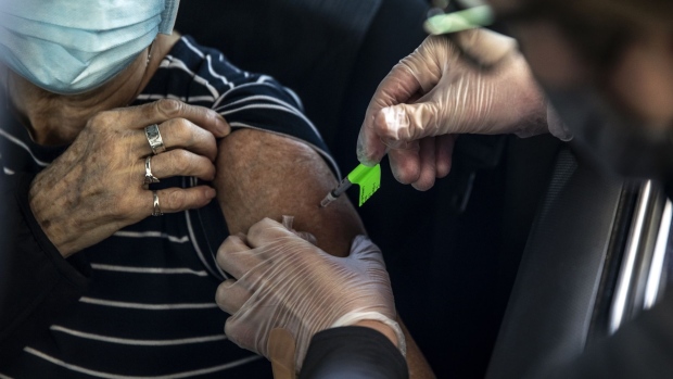 A healthcare worker administers a dose of the Pfizer-BioNTech Covid-19 vaccine at Coors Field in Denver, Colorado, U.S., on Saturday, Feb. 20, 2021. More than 1 million doses of Covid-19 vaccines have been administered to Coloradans to date as public health officials are nearing their goal of inoculating 70% of all people 70 and older, state representatives said Thursday. Photographer: Chet Strange/Bloomberg