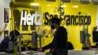 A customer checks in at the Hertz rental counter at San Francisco International Airport in San Francisco, California, U.S., on Wednesday, Oct. 27, 2021. Hertz Global Holdings Inc., fresh off a blockbuster order for 100,000 Teslas, reached an exclusive agreement to supply Uber drivers with electric vehicles and signed up Carvana Co. to dispose of rental cars it no longer wants. Photographer: David Paul Morris/Bloomberg
