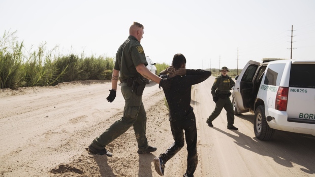 U.S. Border Patrol agents capture a migrant near the U.S. and Mexico border fence in Calexico, California, U.S., on Tuesday, Sept. 14, 2021. The number of undocumented immigrants apprehended trying to cross the southern border is down slightly compared to this time last month, when crossings were at a 21-year high, NBC News reports.