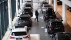 An employee between new BMW automobiles inside a BMW AG showroom in Berlin, Germany, on Thursday, Aug. 19, 2021. Automakers are set to benefit from rising vehicle prices in Europe because of supply bottlenecks for semiconductors and other materials, according to credit insurer Euler Hermes.