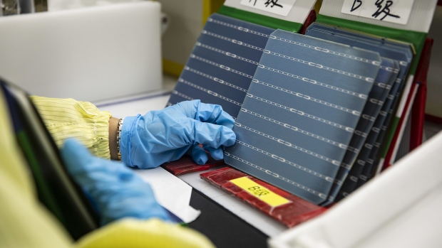 An employee inspects photovoltaic cells on the production line at the Longi Green Energy Technology plant in Xi'an, Shaanxi Province, China. Photographer: Qilai Shen/Bloomberg