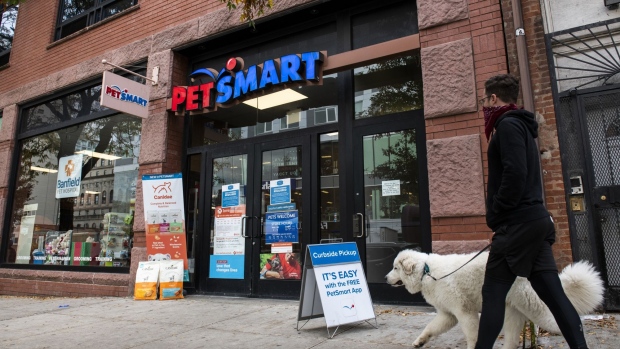 A pedestrian wearing a protective mask walks a dog outside a PetSmart store in the Brooklyn borough of New York, U.S., on Tuesday, Oct. 27, 2020. PetSmart Inc. is kicking off a $2.35 billion junk bond offering as part of a larger financing package that will separate the company from its online counterpart Chewy Inc. Photographer: Mark Kauzlarich/Bloomberg