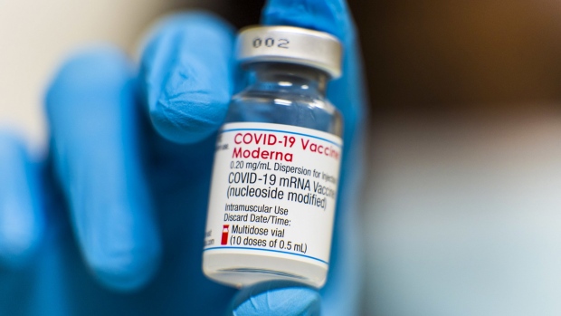 A health worker holds a vial of the Moderna Inc. Covid-19 vaccine at the Banco Santander SA headquarters in Boadilla del Monte, Spain, on Tuesday, July 6, 2021. Santander signed a deal with the Madrid regional government for residents to get vaccinated at its HQ building outside the capital.