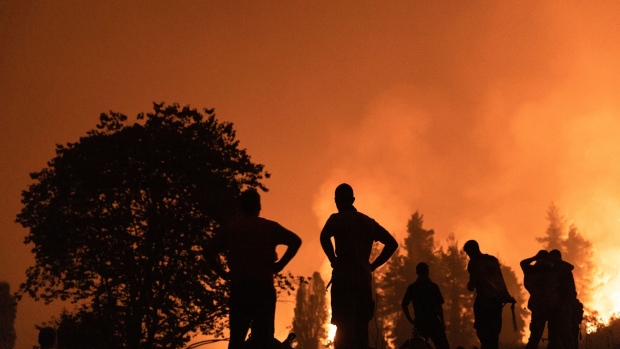 Residents watch the wildfire while waiting to support firefighters outside the village of Kamatriades, on Evia island, Greece, on Monday, Aug. 9, 2021. Thousands of residents were evacuated from the Greek island of Evia by boat after wildfires hit Greece’s second biggest island.