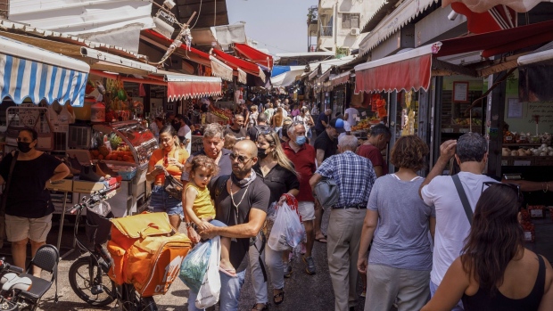 Shoppers pass between stalls in Carmel Market in Tel Aviv, Israel, on Monday, Sept. 20, 2021. A third dose of the Pfizer Inc.-BioNTech SE Covid vaccine can dramatically reduce rates of Covid-related illness in people 60 and older, according to data from a short-term study in Israel. Photographer: Kobi Wolf/Bloomberg