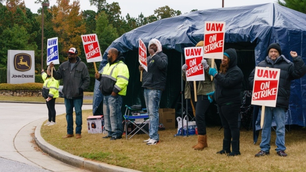 Workers hold signs during a strike outside the John Deere Regional Parts Distribution facility in McDonough, Georgia, on Nov. 5.