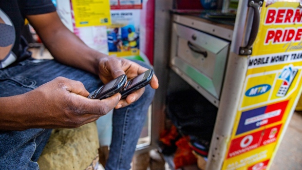 A vendor performs a mobile money transaction on a street-side kiosk in Accra, Ghana, on Tuesday, April 22, 2021. MTN Group Ltd. values its mobile-money arm at about $5 billion and will consider a listing of the division, joining African wireless carriers trying to monetize a service that is particularly popular on the continent. Photographer: Nipah Dennis/Bloomberg