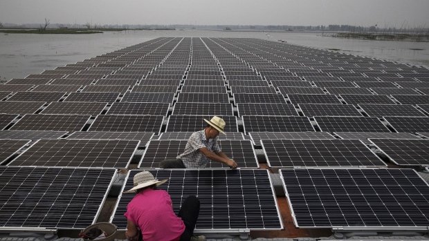 HUAINAN, CHINA - JUNE 12: Chinese workers prepare panels that will be part of a large floating solar farm project under construction by the Sungrow Power Supply Company on a lake caused by a collapsed and flooded coal mine on June 12, 2017 in Huainan, Anhui province, China. The floating solar field, billed as the largest in the world, is built on a part of the collapsed Panji No.1 coal mine that flooded over a decade ago due to over-mining, a common occurence in deep-well mining in China's coal heartland. When finished, the solar farm will be made up of more than 166,000 solar panels which convert sunlight to energy, and the site could potentially produce enough energy to power a city in Anhui province, regarded as one of the country's coal centers. Local officials say they are planning more projects like it, marking a significant shift in an area where long-term intensive coal mining has led to large areas of subsidence and environmental degradation. However, the energy transition has its challenges, primarily competitive pressure from the deeply-established coal industry that has at times led to delays in connecting solar projects to the state grid. Chinaâs government says it will spend over US $360 billion on clean energy projects by 2020 to help shift the country away from a dependence on fossil fuels, and earlier this year, Beijing canceled plans to build more than 100 coal-fired plants in a bid to ease overcapacity and limit carbon emissions. Already, China is the leading producer of solar energy, but it also remains the planetâs top emitter of greenhouse gases and accounts for about half of the worldâs total coal consumption. (Photo by Kevin Frayer/Getty Images)