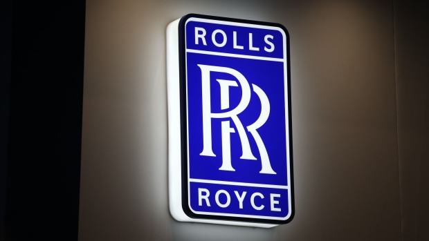 A Rolls Royce Holdings Plc logo at a stall on the opening day of the Defence and Security Equipment International (DSEI) 2021 exhibition in London, U.K., on Tuesday, Sept. 14, 2021. U.K. aerospace and defense firms have become a popular target for buyers, including private-equity firms. Photographer: Hollie Adams/Bloomberg